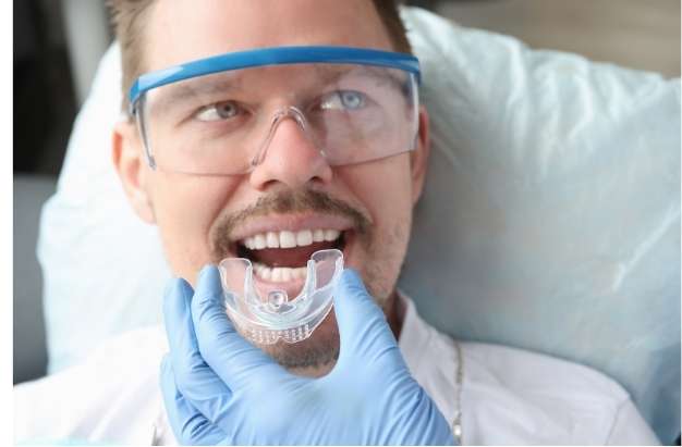 Creating a Custom-Fitted Mouthguard Dentist taking dental impression for custom mouthguard