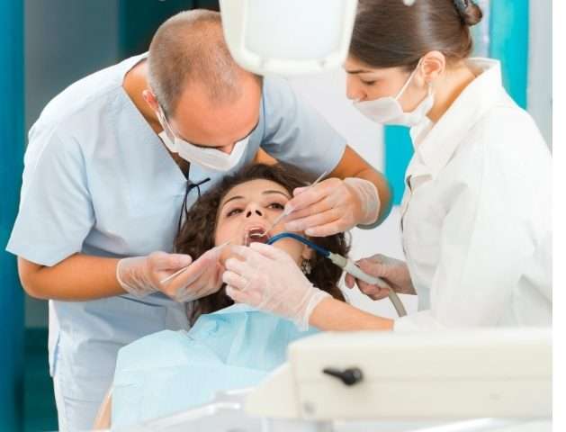Dentist performing tooth extraction